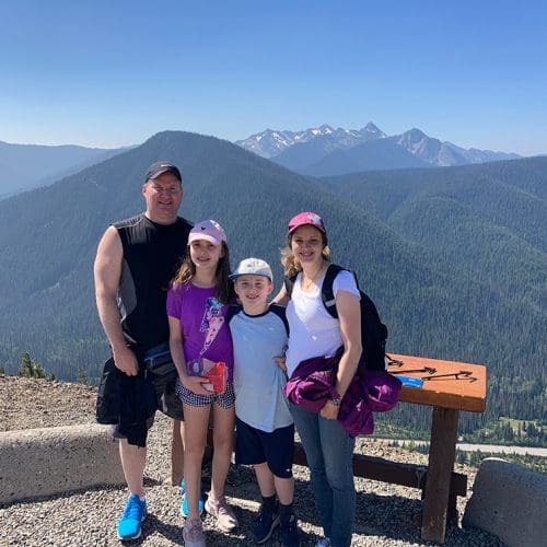 family of 4 standing at Cascade Lookout, a viewpoint overlooking the cascade mountain range